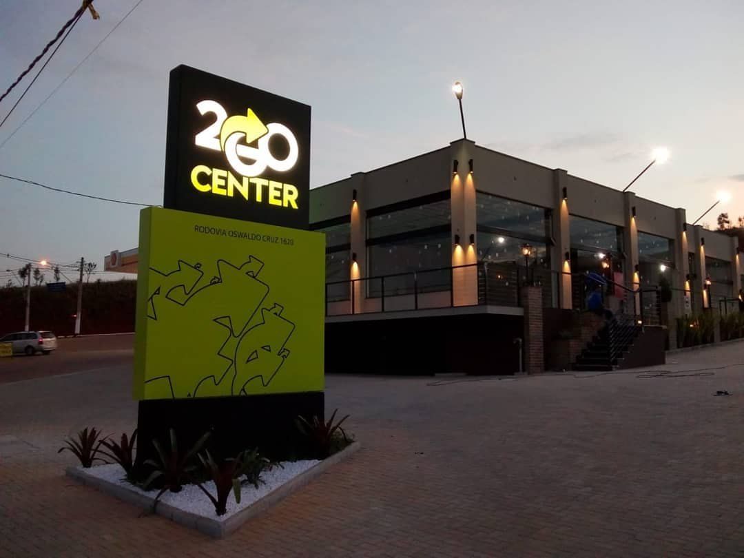 Totem do 2GO Center com logo iluminado ao entardecer