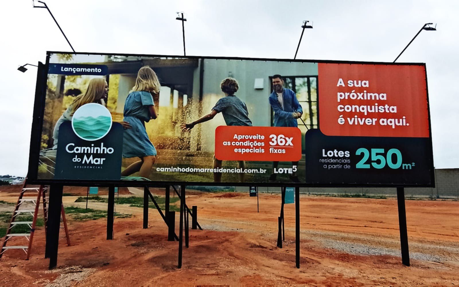 Outdoor do loteamento Caminho do Mar em estrutura metálica sobre terra vermelha